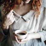 front view girl wearing dress and holding cup of coffee
