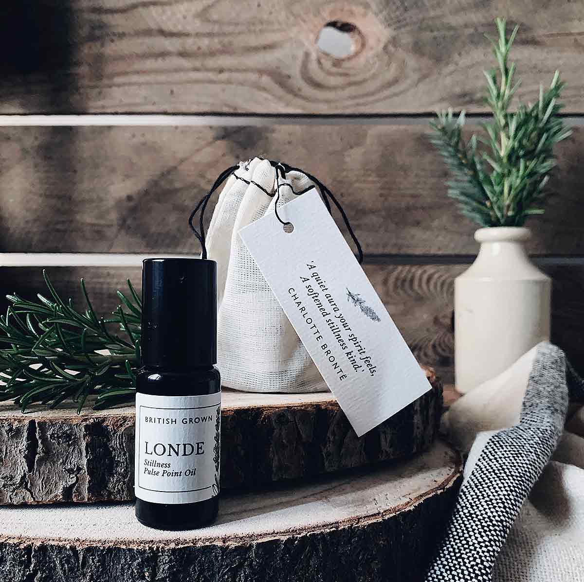 bottles and towel on wood logs with vase of herbs