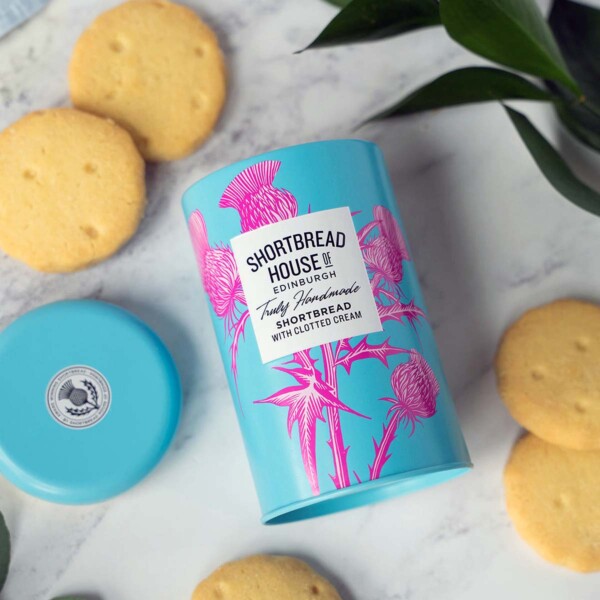 open tin and biscuits on a white tablecloth