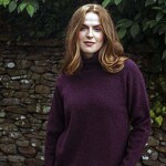 woman wearing jumper in front of a natural stone wall