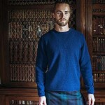 man in kilt wearing jumper in a library