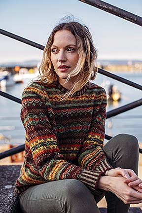 woman wearing a fair isle jumper with a harbour view behind
