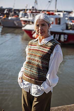 woman wearing wool vest over white shirt in a harbour scene