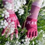 mittens worn on hands amongst white flowers