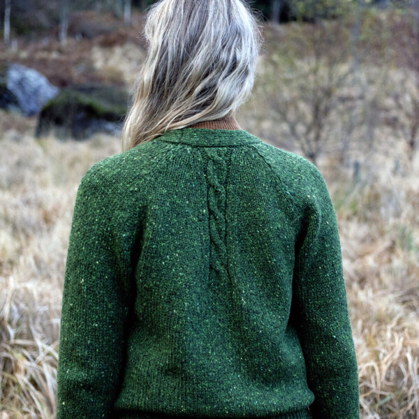 rear view of woman wearing cardigan in woodland clearing