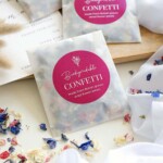 packets of confetti on white cloth with loose confetti
