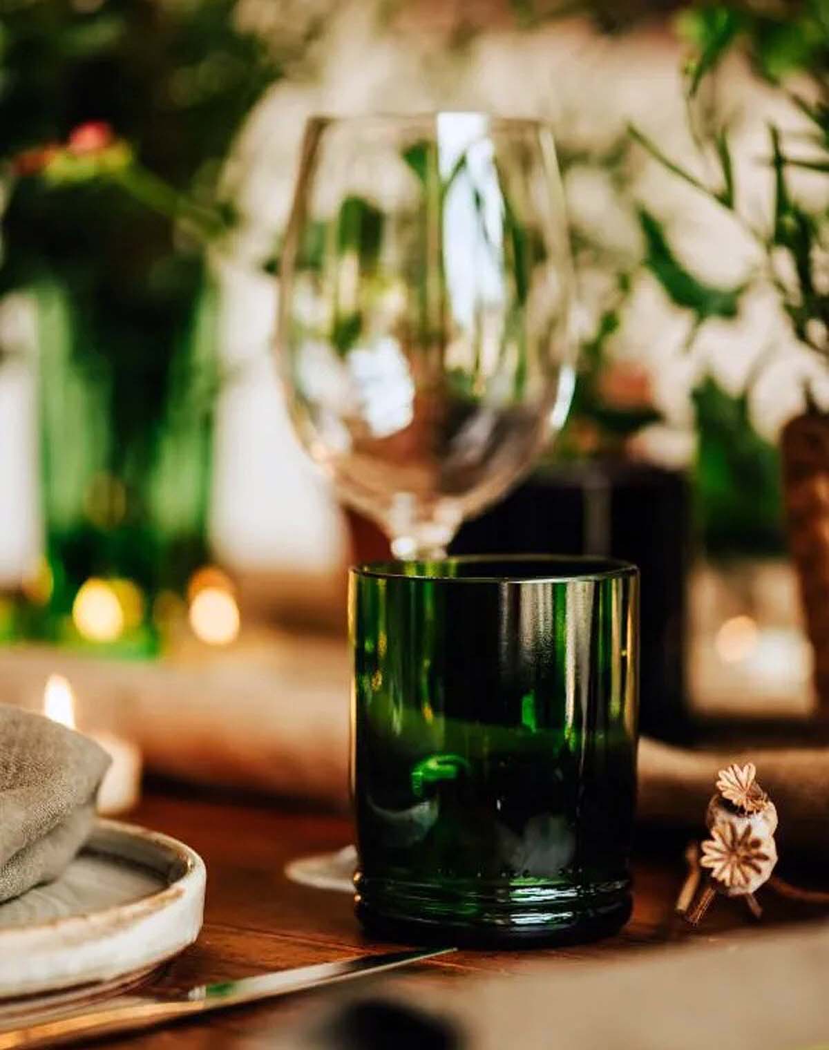 dark-green-tumbler-glass green tumbler on a laid dining table
