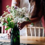 vase with flowers being placed on a cloth on a table
