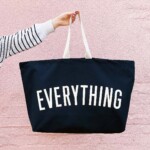 arm holding bag against a pale pink wall