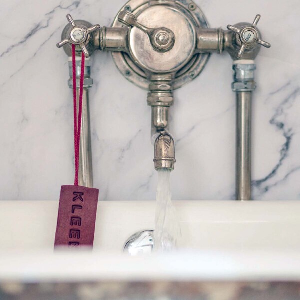 soap on road hanging from bath tap mounted on marble surround
