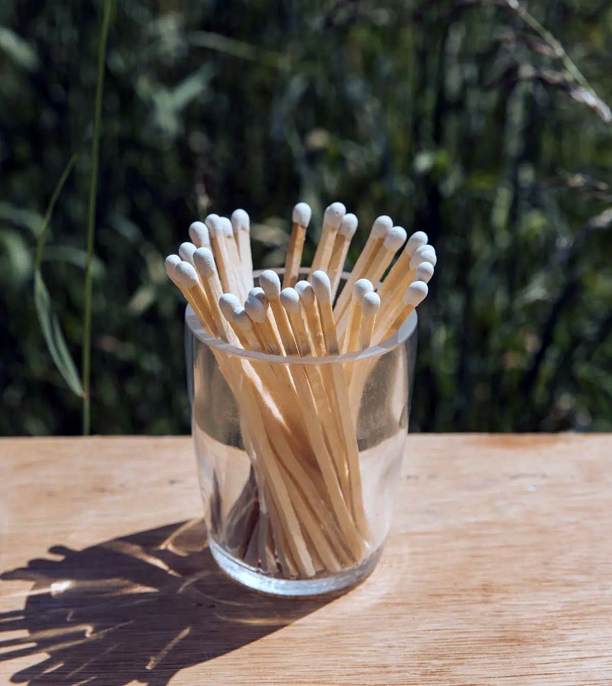 recycled-glass-pot -with-matches glass pot with matches on table outdoors